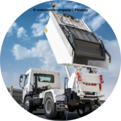 Müllwagen mit angehobenem Containeraufbau auf einer Straße, vor blauem Himmel mit Wolken.
